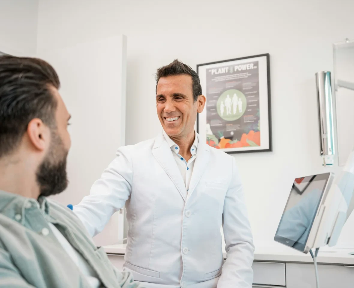 A dentist talking with a patient in a consultation room.