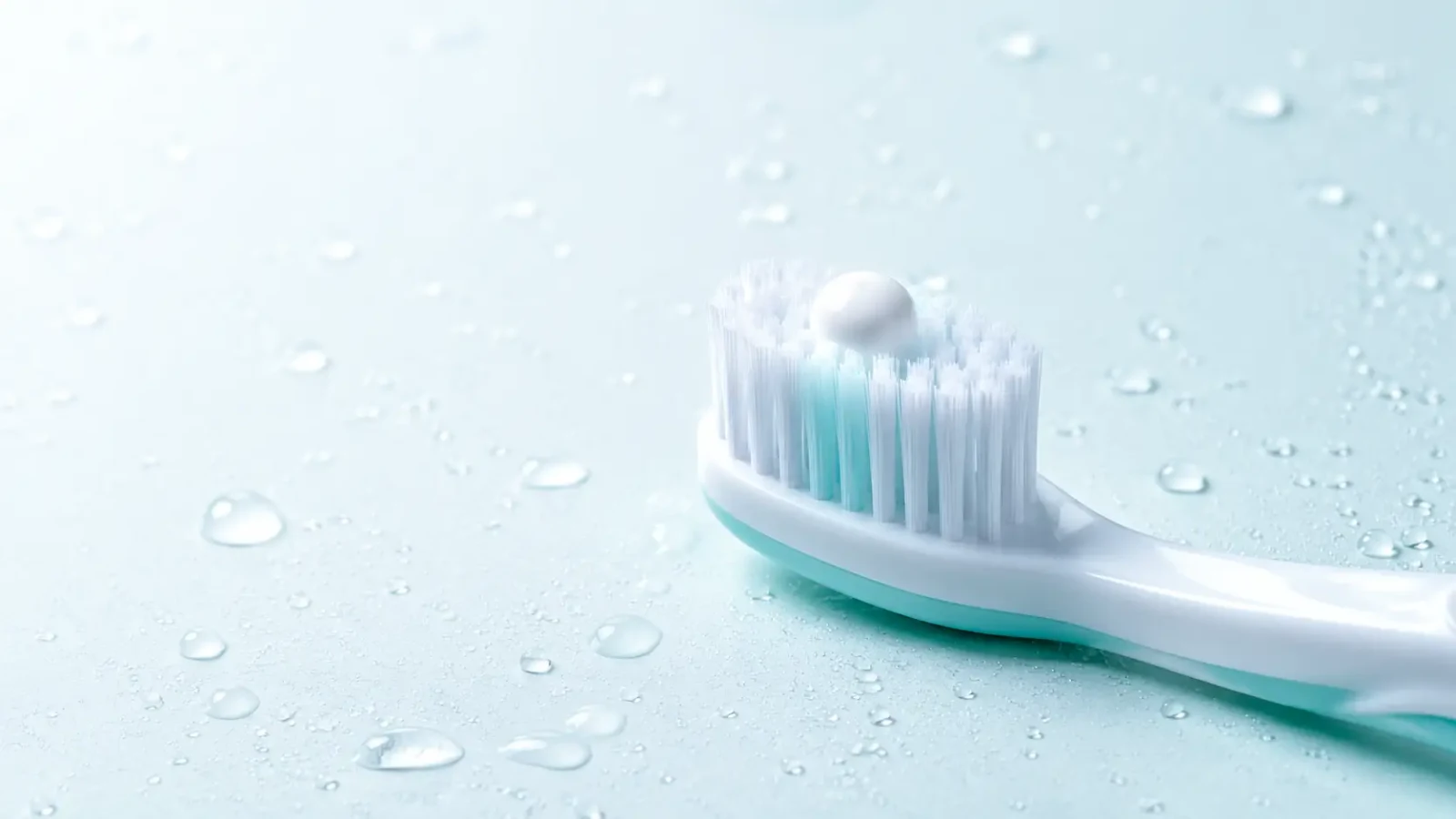 A pea-sized amount of toothpaste on the head of a soft-bristled toothbrush.